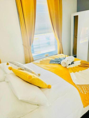 a bed with orange and white sheets and a window at Alver House in Portsmouth