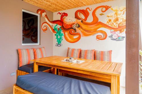 a dining room with a table and an octopus on the wall at Casa Tranquila - Ciudad del Mar 90 in Jacó