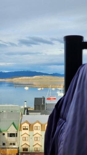 a person is looking out at the water and buildings at YAGHAN HOSTEL in Ushuaia