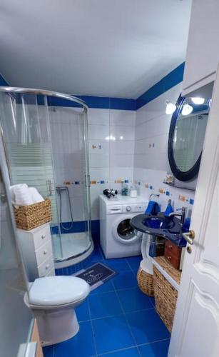 a bathroom with a shower toilet and a washing machine at Christina's Cozy Apartment Volos in Volos