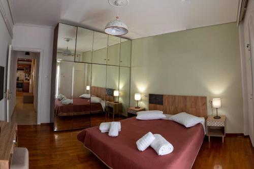 a bedroom with a large bed with towels on it at Christina's Cozy Apartment Volos in Volos