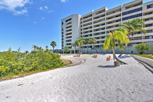 a beach with chairs and a palm tree in front of a building at Scenic Balcony and Beach Access Hudson Condo in Hudson