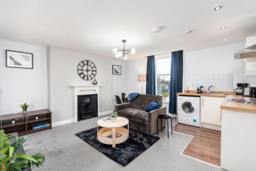 a living room with a couch and a chair and a fireplace at Stunning Doncaster City Centre Apartment, with 2 Double beds in Doncaster