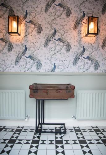 a table in a room with a wall with birds on it at Blackwell House in Banbridge