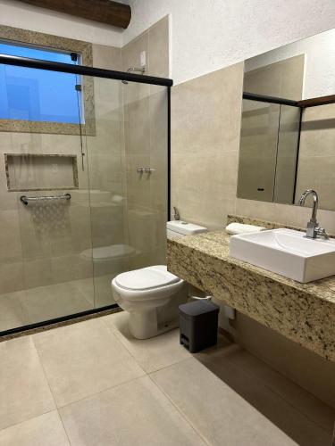 a bathroom with a toilet and a sink and a shower at Village Sana Apart Hotel in Sana