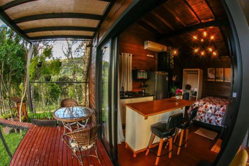 a kitchen and dining area of a tiny house at Cabana Agatha - Alfredo Wagner SC in Barracão