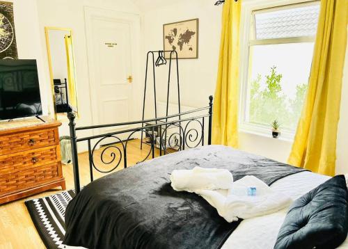 a bedroom with a bed and a television and a window at Taswell House in Portsmouth