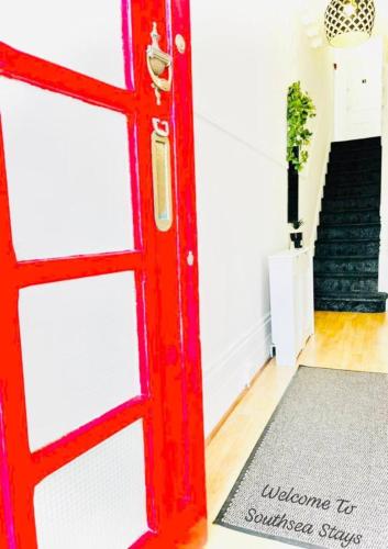 a red door in a room with a staircase at Taswell Road in Portsmouth