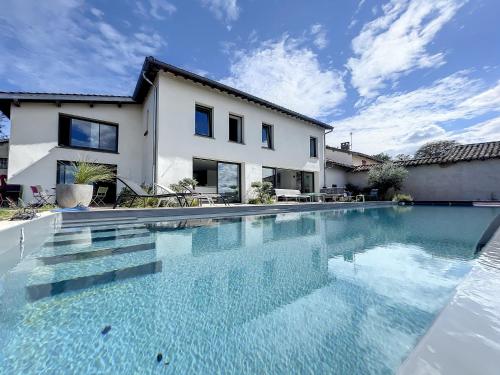 une piscine devant une maison dans l'établissement Domaine de l'Heure Bleue, à Genouilleux