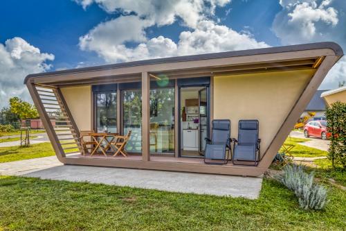 a tiny house with a porch and two chairs at River View Suite Mlinar Private Beach - Happy Rentals in Metlika