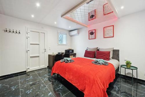 a bedroom with a bed with a red blanket at Love Room - Suite avec jacuzzi et sauna privatif in Corbeil-Essonnes