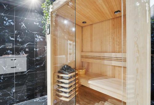 a bathroom with a sauna with a glass wall at Love Room - Suite avec jacuzzi et sauna privatif in Corbeil-Essonnes