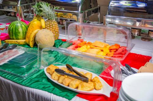 a table with a tray of fruits and vegetables at Sportsmens Lodge - Gentlemen's Club in San José
