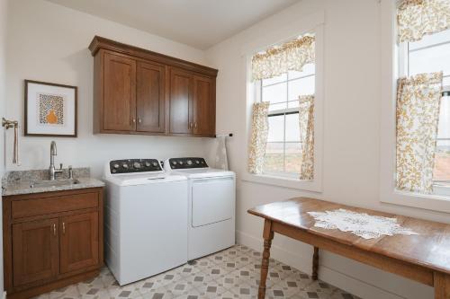 a kitchen with a washing machine and a table at Hidden Springs RV Resort in Ivins