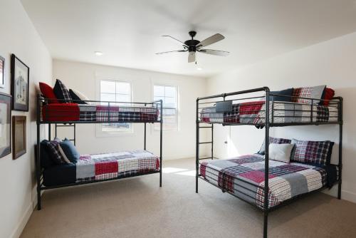 two bunk beds in a room with a ceiling fan at Hidden Springs RV Resort in Ivins