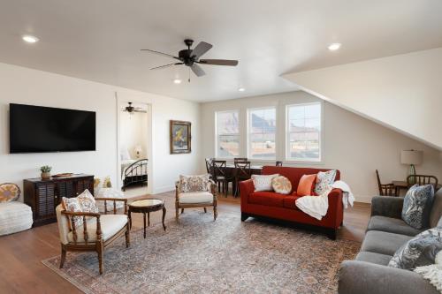 a living room with a red couch and chairs at Hidden Springs RV Resort in Ivins