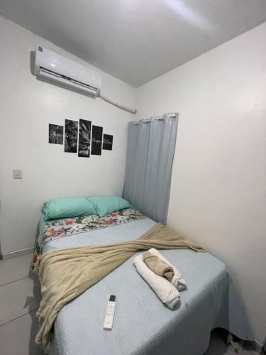 a bedroom with a bed with a remote control on it at Flat J&C próx Praia da graciosa e UFT e Unitins in Palmas