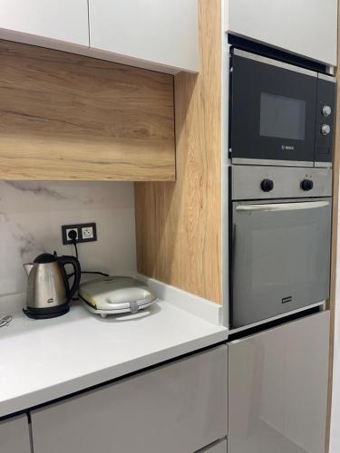 a kitchen with a microwave and a stove top oven at Appartement pied sur mer in Fnidek