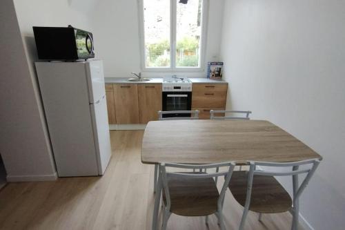 une cuisine avec une table en bois et un réfrigérateur dans l'établissement Appartement à la campagne, à Commer