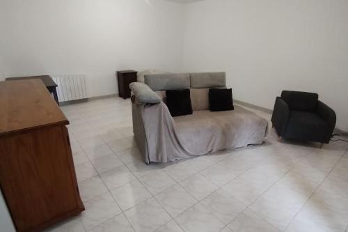 - une chambre avec un lit doté d'oreillers et d'une chaise dans l'établissement Appartement à la campagne, à Commer