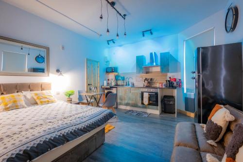 a bedroom with blue walls and a bed and a couch at Renovated Studio - Free Parking - Great Location in Leeds