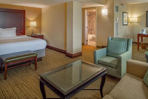 a hotel room with a bed and a chair and a table at Crowne Plaza Hotel St. Louis Airport by IHG in Bridgeton