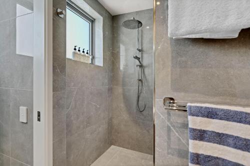 a bathroom with a shower with a glass door at Breathtaking Beachfront 3 Bedroom Penthouse Bokarina Sunshine Coast in Bokarina
