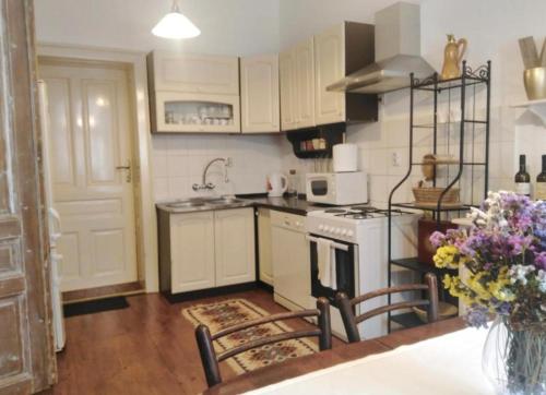 a kitchen with white cabinets and a white stove top oven at Šomin lagum - Guest house in Sremski Karlovci