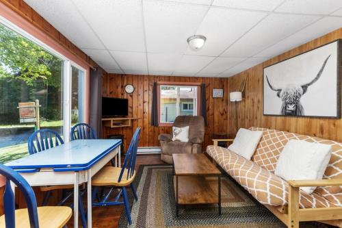 a living room with a couch and a table at Chippewa Bluffs Resort Spacious Combined 2BR 2BA Cabins in Barryton