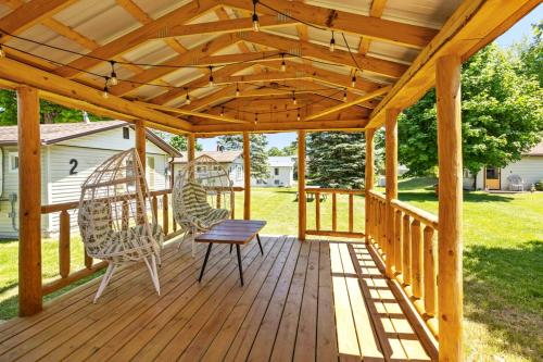 a wooden pergola with two chairs and a table on a deck at Chippewa Bluffs Resort Spacious Combined 2BR 2BA Cabins in Barryton