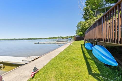 a couple of blue kayaks sitting on the grass next to a dock at Chippewa Bluffs Resort Spacious Combined 2BR 2BA Cabins in Barryton
