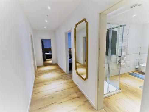 a hallway with a mirror and wooden floors at Apartmenthaus Bargteheide Apartment 1 in Bargteheide