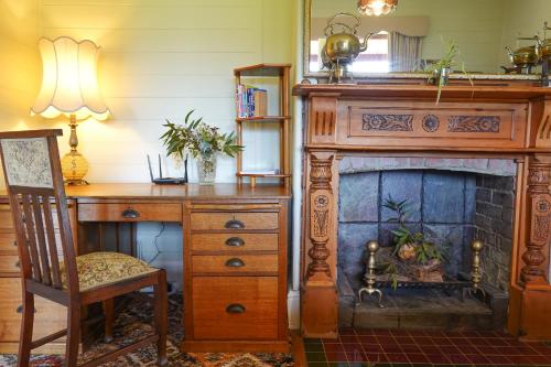 a room with a desk and a fireplace at Waterfront Casilda Guesthouse in Dunalley