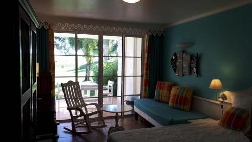 a bedroom with a bed and a couch and a window at Village Sainte Luce, Martinique - maeva Home - Studio 3 Personnes - Prestige MAE-7394 in Sainte-Luce