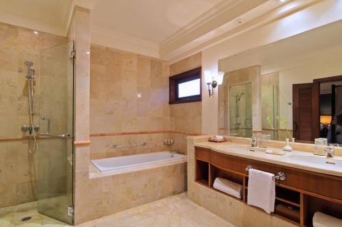 a bathroom with a tub and a sink and a shower at Villa Nirwana in Tanah Lot