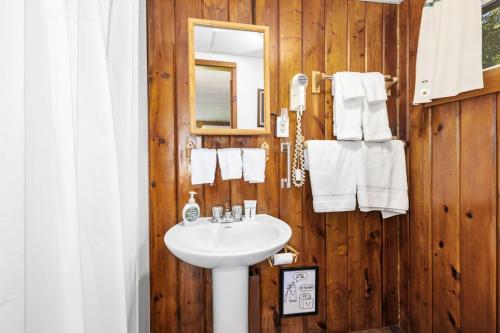 a bathroom with a sink and a mirror and towels at Chippewa Bluffs Resort Spacious Combined 3BR 3BA Cabins in Barryton