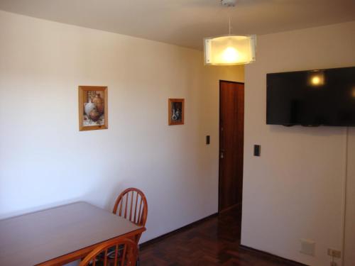 a dining room with a table and a flat screen tv at Departamento Maipu Cordoba in Cordoba