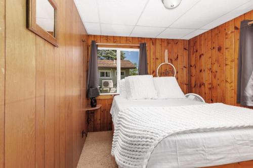 a bedroom with a bed and a window at Chippewa Bluffs Resort Spacious Combined 4BR 4BA Cabins in Barryton