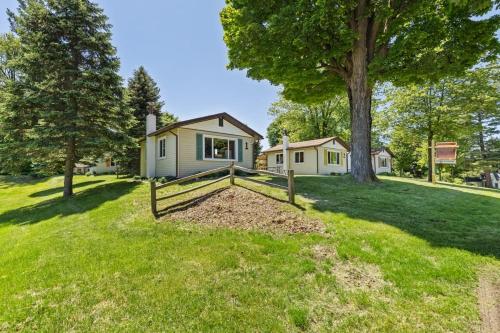 a house with a fence in front of a yard at Chippewa Bluffs Resort Spacious Combined 4BR 4BA Cabins in Barryton