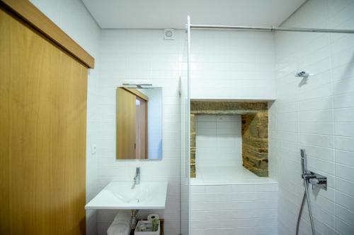 a bathroom with a sink and a shower at Casa de Trás-o-Muro in Vila Real