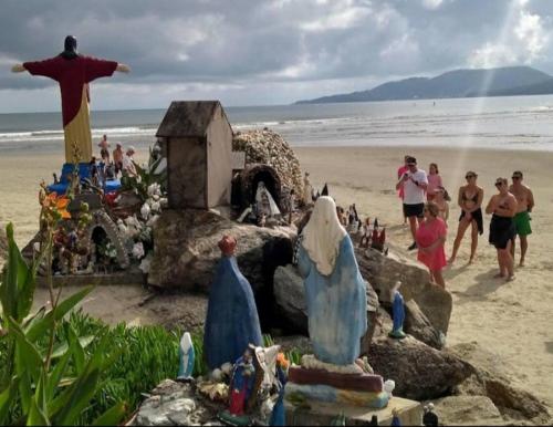 a group of people on a beach with a group of figurines at Apartamento próx ao mar, ao píer O Porto, Hard Rock Café e ao Calçadão Meia Praia in Itapema