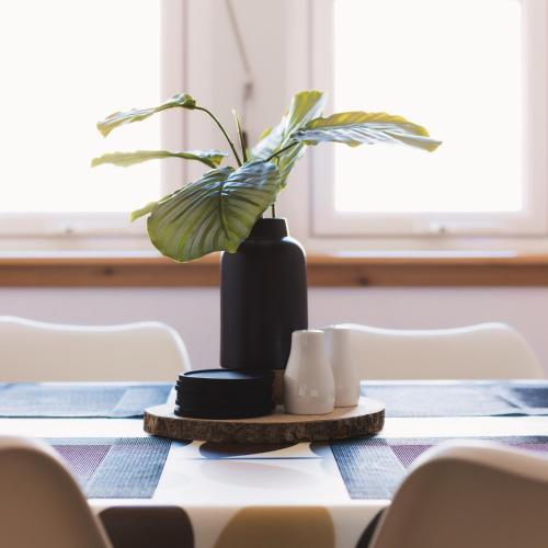 a black vase with a plant on a table at Apartment - Sleeps 4 Pet friendly & Free parking in Anstruther