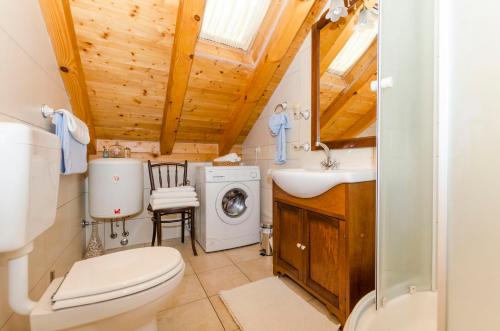 a bathroom with a toilet sink and a washing machine at Apartments Draga in Vrboska