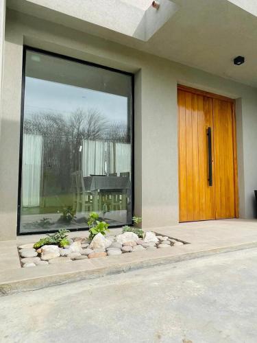 a building with a large window and a wooden door at Casa Quinta en Suipacha in Suipacha