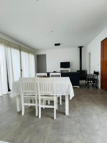 a white dining room with a table and chairs at Casa Quinta en Suipacha in Suipacha