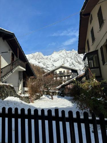a view of a snow covered mountain from a fence at Alpine Chic Retreat in Courmayeur