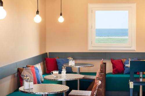 a restaurant with two tables and a window at Greet Hotel Nice Aéroport Promenade des Anglais in Nice