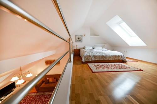 an attic bedroom with a bed and a staircase at Apartments at Villa Golf in Rogaška Slatina