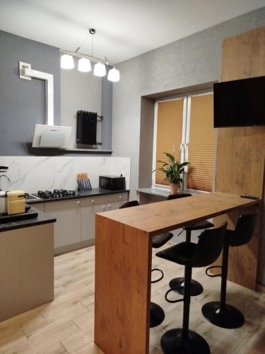 a kitchen with a wooden table and some chairs at Studio Pocztówka in Zgierz