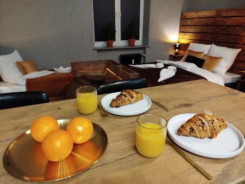 a table with plates of oranges and glasses of orange juice at Studio Pocztówka in Zgierz